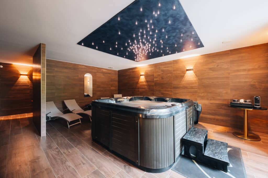 Espace bien-être d'un hôtel spa en Dordogne avec jacuzzi, transats et lumière tamisée