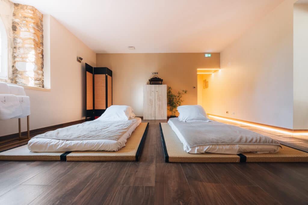 Salle de massage zen dans un hotel spa en Dordogne, avec futons pour massage au sol